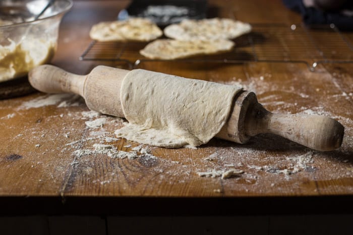 Campfire Chapati Flatbread on a cooling rack withone draped over a floury rolling pin