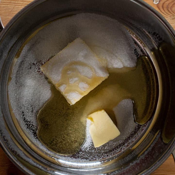 Inside shot of a silver saucepan with butter, sugar and honey waiting to be melted together