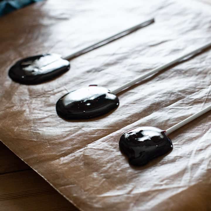 blackberry lollipops cooling on a marble slab