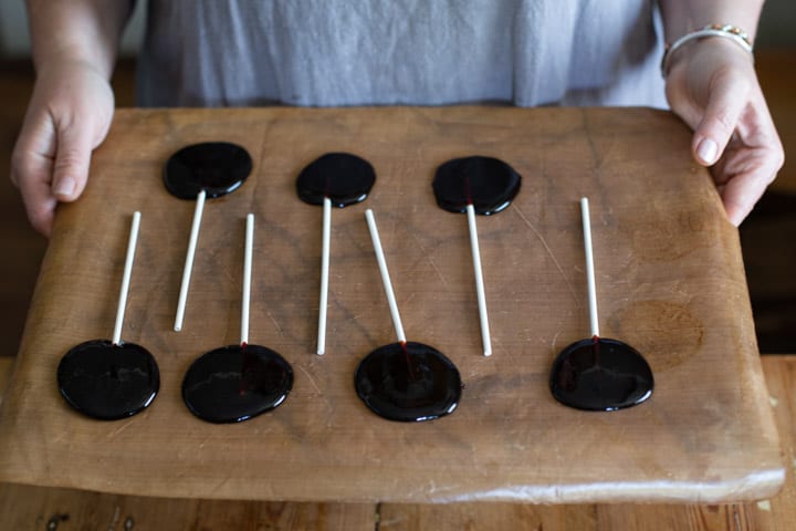 woman in grey holding a tray of blackberry candies