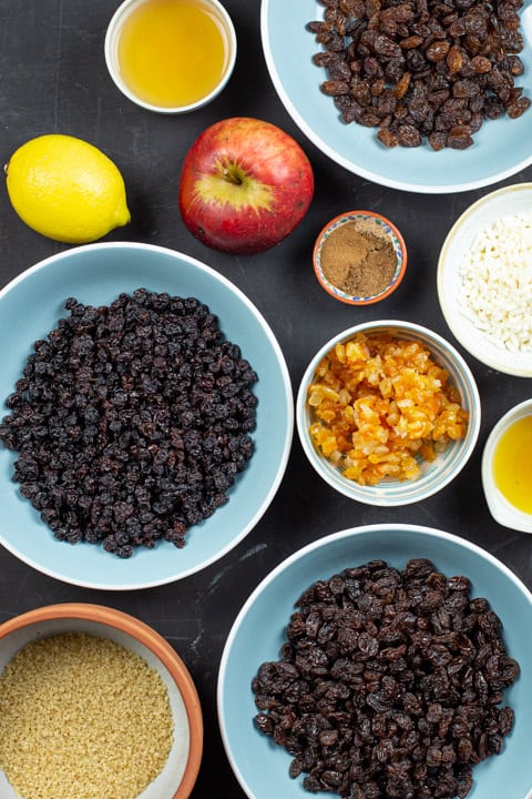 Ingredients in bowls for making best mincemeat recipe including apple, syrup, suet and dried fruits