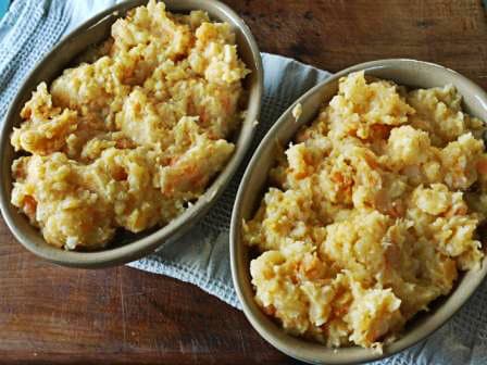 Poachers Squirrel Pie with Mixed Root Mash Topping in individual pie dishes on a wooden table