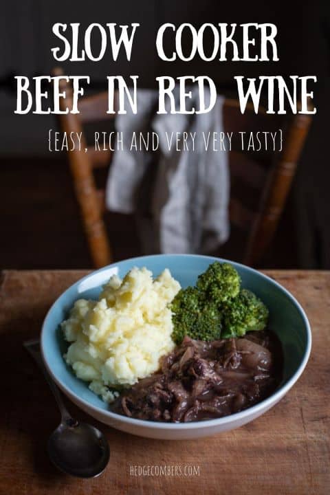 pale blue bowl on wooden kitchen surface filled with mashed potatoes, broccoli and beef in red wine stew