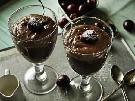 Dark Chocolate Rum Mousse in glass dishes on a tray with a bowl of cherries, a jug of cream and 2 spoons 