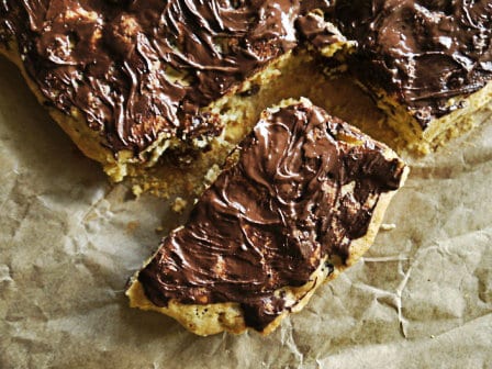 Fruit and Nut Traybake with one slice removed on baking parchment