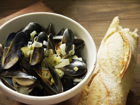 Dairy Free Moules Mariniere in a white bowl with french bread on a wooden board