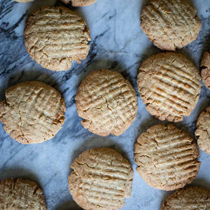 close up of some ginger biscuits cooling on a marble sheet