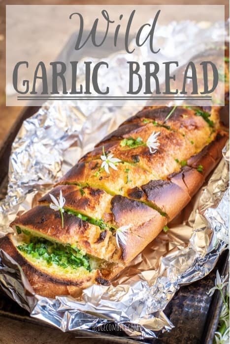 golden brown wild garlic bread fresh from teh oven still wrapped in tin foil with white wild garlic flowers on top