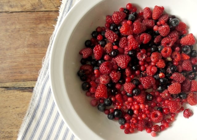Summer fruits for individual summer puddings in a white bowl