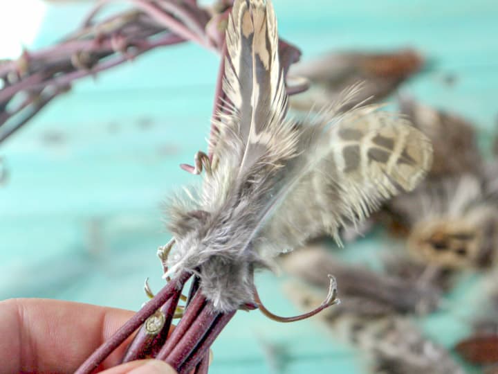 hand made pheasant feather wreaths against a blue wooden background