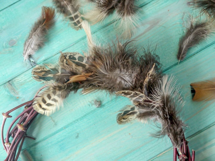 hand made pheasant feather wreaths against a blue wooden background