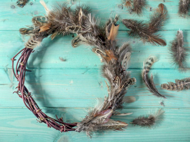 hand made pheasant feather wreaths against a blue wooden background