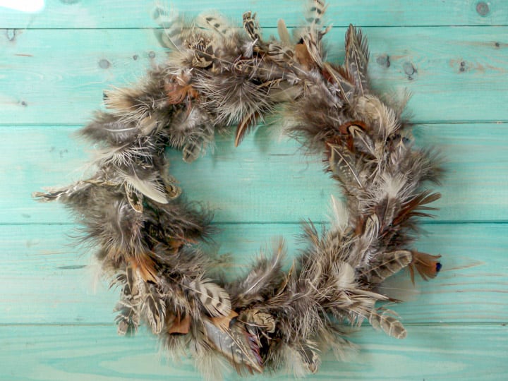 hand made pheasant feather wreaths against a blue wooden background