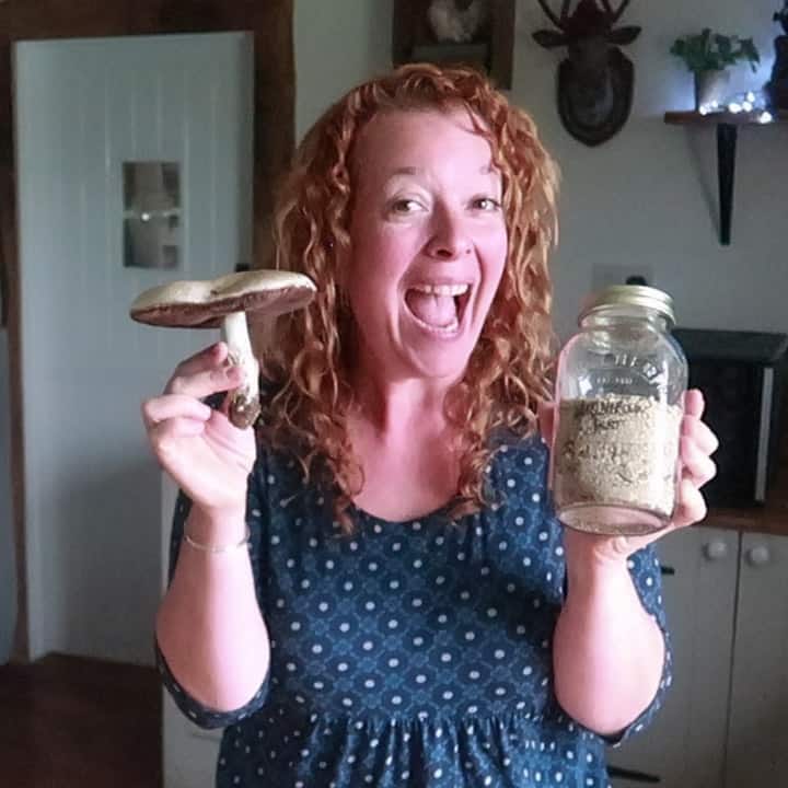 Smiling woman holding a mushroom and a jar of mushroom powder