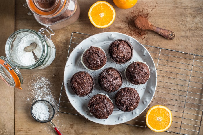 Chocolate Orange Muffins on a white plate surrounded by baking products