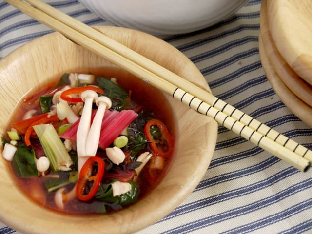 Japanese Style Chicken and Shimeji Mushroom Soup in bowls with chopsticks on a stripedcloth