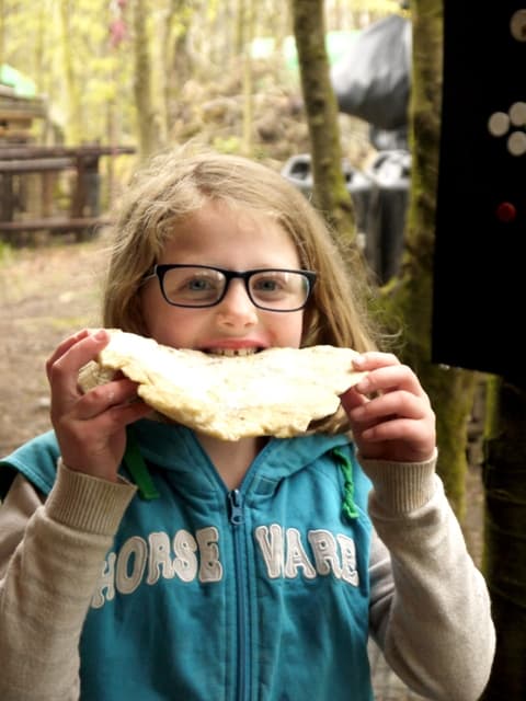 Young girl eating flatbread outdoors