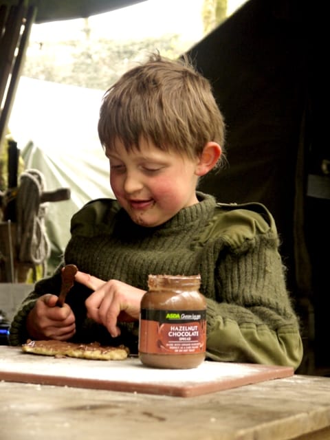boy putting chocolate spread onto flatbread recipe