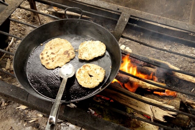 3 flatbreads made using a simple flatbread recipe in a skillet cooking over a campfire