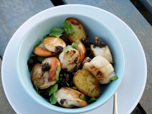 Scallops, New Potatoes and Crumbled Black Pudding in a white bowl