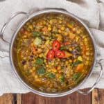 metal bowl of lentil curry on a wooden background