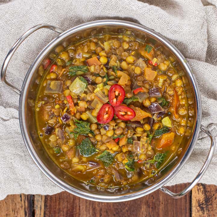 metal bowl of lentil curry on a wooden background