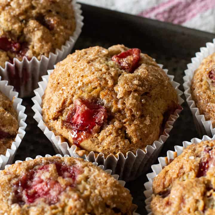 moist strawberry muffins on a black baking tray