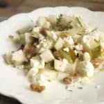 White plate with pear walnut and feta salad