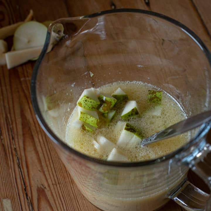 an inside shot of a jug of milk, egg and chopped pear to make spiced pear muffins