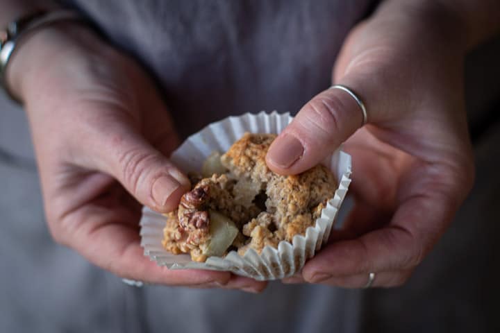 womans hands showing the moist inside of a spiced pear muffin