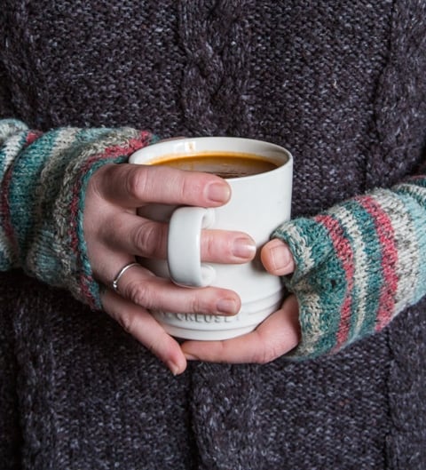 Red Pepper and Sundried Tomato Soup  in a mug being cradled in a pair of hands