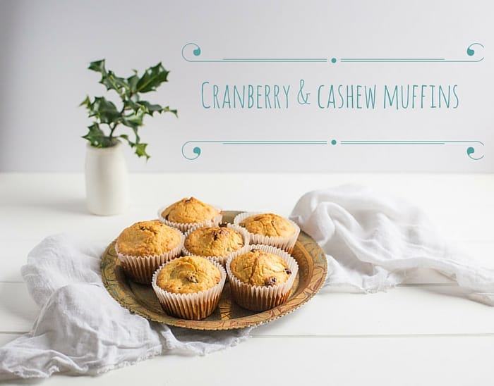 cranberry and cashew muffins on a plate against a white background with sprigs of holly, one of my 25 Homemade Christmas Gift Ideas