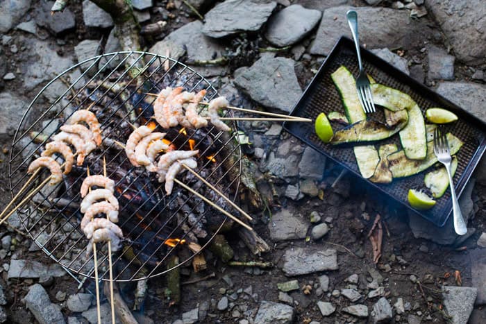 Beach campfire with grilled king prawns, courgette and wedges of lime