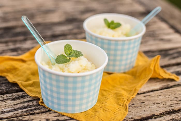 Pineapple and Dark Rum Instant Sorbet in blue and white checked pots with spoons on a yellow cloth on a wooden table