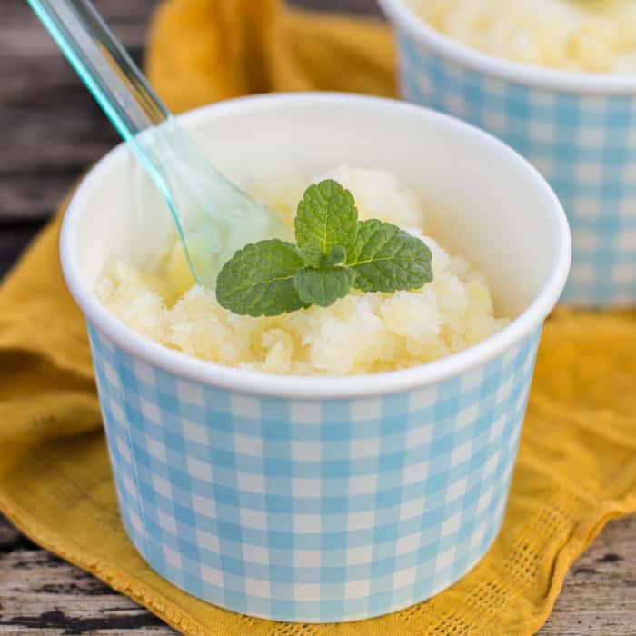 Pineapple and Dark Rum Instant Sorbet in blue and white checked pots with spoons on a yellow cloth on a wooden table