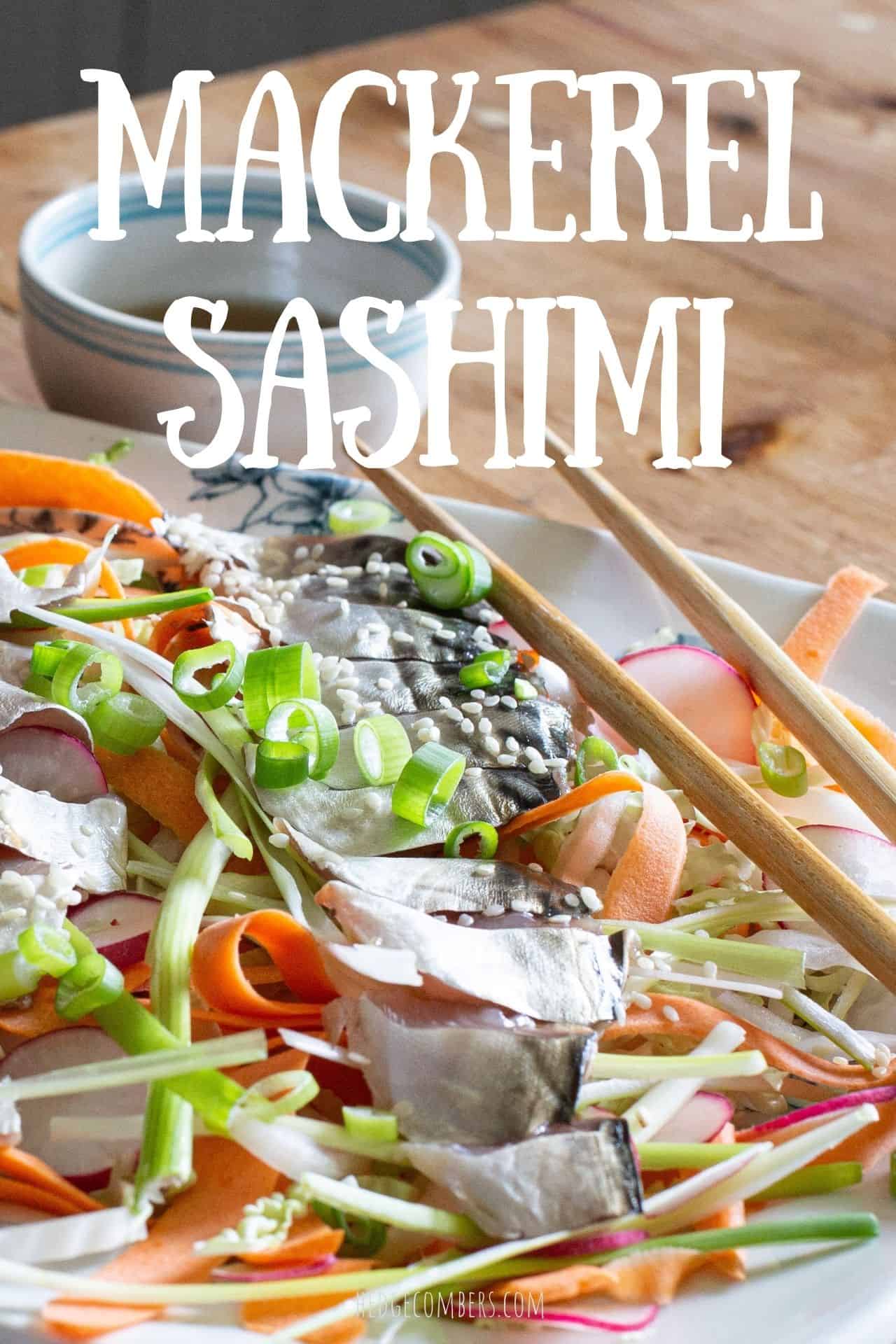 white plate on wooden surface topped with orange and green salad and a fillet of fresh mackerel sashimi sliced on top