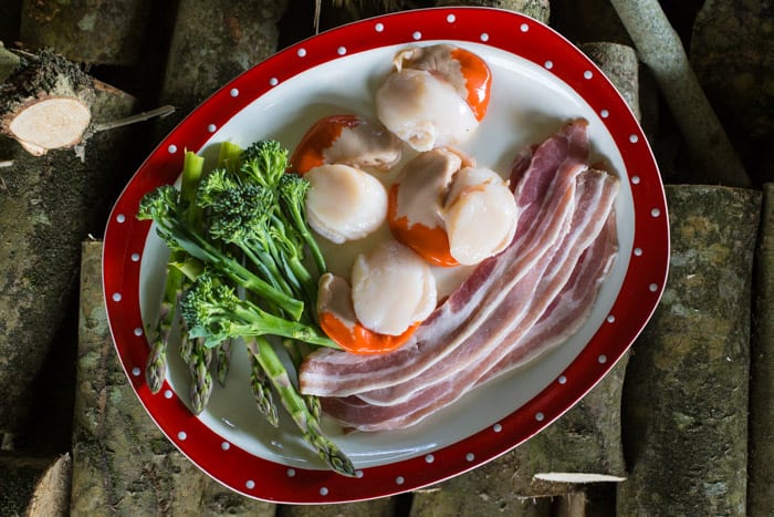BBQ Scallops in Bacon on a white plate with asparagus spears and broccolli