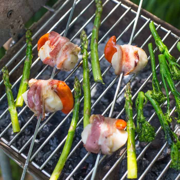 BBQ Scallops in Bacon on a barbecue grill with asparagus spears