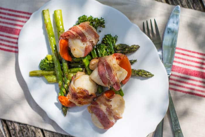 BBQ Scallops in Bacon on a white plate with asparagus spears