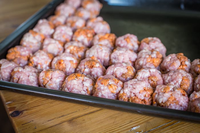  Spicy n'duja meatballs on a baking sheet on a wooden table