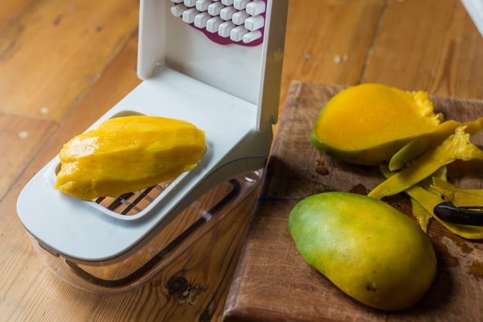 Mojito Fruit Salad Dressing chopping a mango fruit with an oxo good grips vegetable chopper 