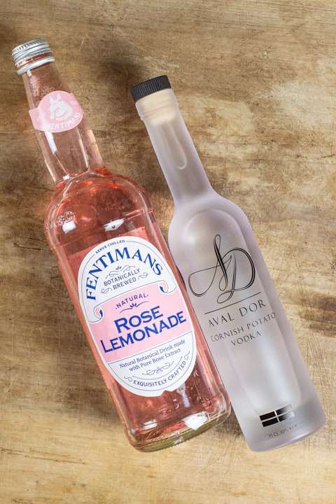 Bottles of Fentimans Rose Lemonade and Aval Dor Vodka lying side by side on a wooden surface