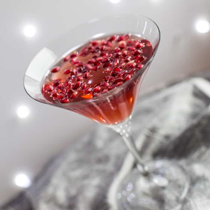 acocktail glass on a silver tray filled with Pomagranate Popper Cocktail
