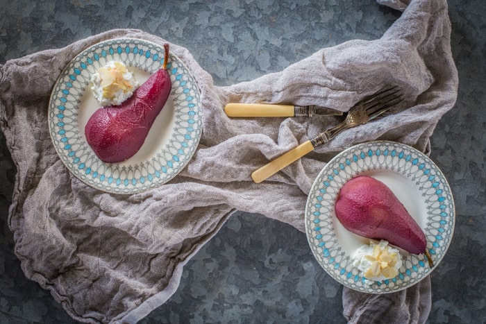 Poached Pears ( naturally sugar free) in blue patterned bowls with greek yoghurt and toasted almonds