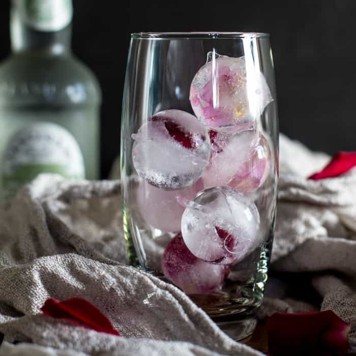 Rose and Elderflower Mocktailover ice in a tall glass with bottle of tonic and rose petals