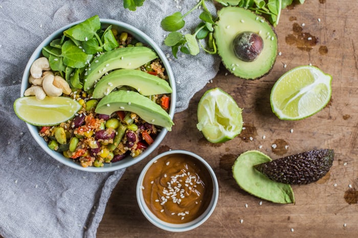 Vegan Buddha Bowl with Spicy Peanut Dressing on a white cloth