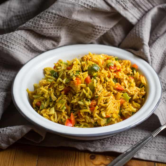 One Pot Campervan Egg Fried Rice in a white bowl on a grey cloth