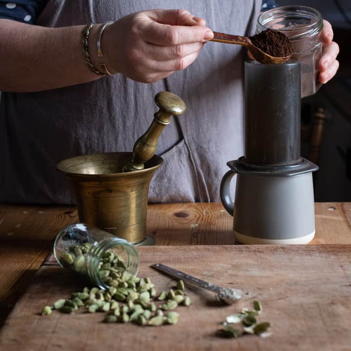 womans hands measuring coffee into an Aeropress coffee maker