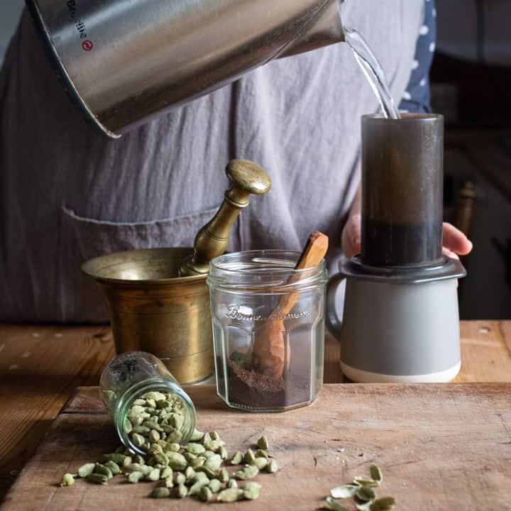 womans hands pouring hot water into an Aeropress coffee maker