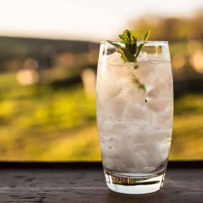 Elderflower & Vodka Cocktail Slush in a tall glasson an outdoor table .